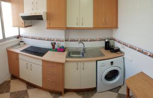 a kitchen with a sink and a washing machine at Chamartin I in Alicante