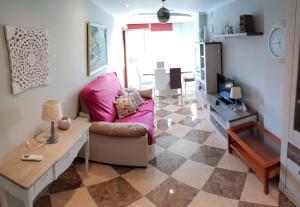 a living room with a pink couch and a table at Chamartin I in Alicante