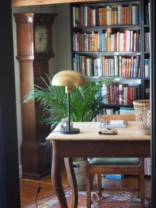 a desk with a lamp and a book shelf with books at Elins Lycka i Viken in Viken