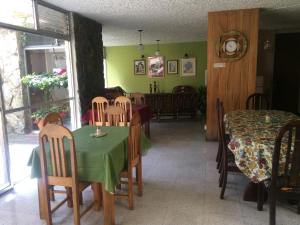 comedor con mesa verde y sillas en Hostal Los Lagos Inn en Guatemala