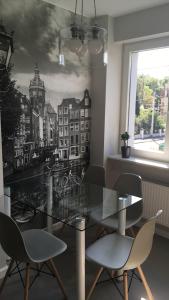 a dining room with a glass table and chairs at Villa Ilava in Iława