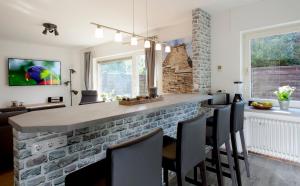 a kitchen with a stone bar with chairs at Gästehaus „bei Pohls“ in Bruchhausen-Vilsen