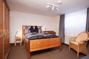 a bedroom with a bed and a chair and a window at Gästehaus „bei Pohls“ in Bruchhausen-Vilsen