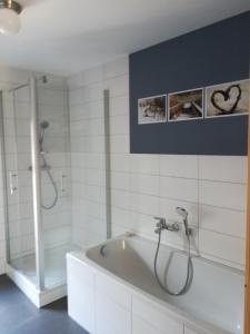 La salle de bains est pourvue d'une baignoire et d'une douche. dans l'établissement Ferienhof"WaldEsel Rippersroda", à Rippersroda