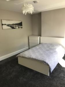 a bedroom with a bed and a painting on the wall at Two Little Ducks Guesthouse in Ellesmere Port