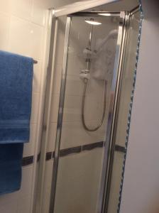 a shower in a bathroom with a blue towel at Ortari@70 in Bishopston