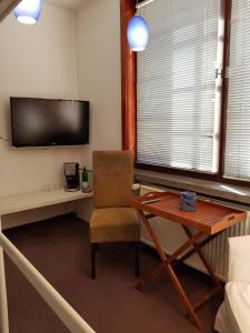 ルドルシュタットにあるCasa Conneのデスク、椅子、テレビが備わる客室です。