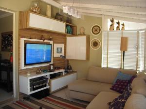 sala de estar con sofá y TV en Apto de cobertura na praia da Cachoeira, en Florianópolis