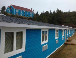 a blue building with a house on top of it at Anchor Inn Hotel and Suites in Twillingate
