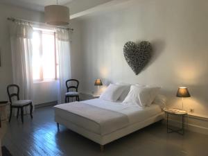 ein Schlafzimmer mit einem Bett mit einem Herz an der Wand in der Unterkunft Maison Ladeveze in Saint-Galmier
