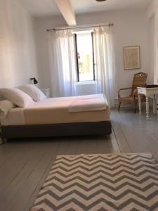 Schlafzimmer mit einem Bett, einem Fenster und einem Teppich in der Unterkunft Maison Ladeveze in Saint-Galmier