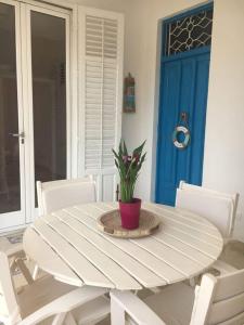ein weißer Tisch und Stühle mit einer Topfpflanze darauf in der Unterkunft Cala Marina Holidays in Trappeto