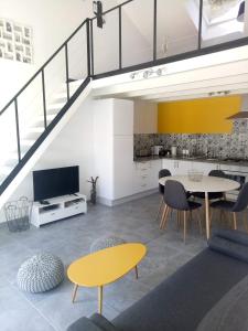 een woonkamer met een gele tafel en stoelen bij B&B le 3 étoiles 