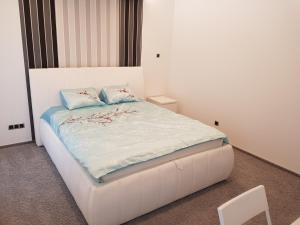 アウグストゥフにあるA1 Augustów Rentのベッドルーム1室(花が咲く白いベッド1台付)