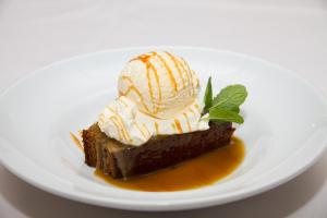 a piece of chocolate cake with ice cream on a white plate at Stronechrubie Accommodation and Restaurant in Mount Somers