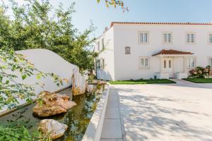 a white house with rocks in front of a driveway at Sra da Oliveira Solar Heritage in Leiria