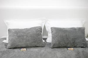 ein Bett mit zwei grauen Kissen und zwei weißen Kissen in der Unterkunft Natalie's Studio in Belgrad