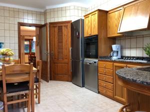 a kitchen with wooden cabinets and stainless steel appliances at Casa Coromines in Alcudia