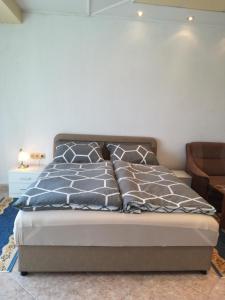 una camera da letto con un letto con cuscini blu e grigi di Prenociste Orhideja a Odžak