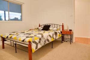 1 dormitorio con 1 cama con ordenador portátil en Sapphire Cottage, en Glen Innes