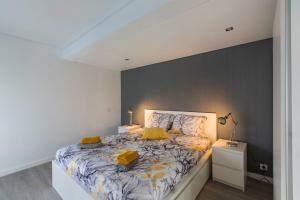 a bedroom with a large bed with yellow pillows at Maria Rita Faro Rooftop Apartment in Faro