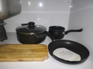 a frying pan sitting on a stove with two pots at Monoambiente en Mendoza in Mendoza