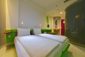 Tempat tidur dalam kamar di POP! Hotel BSD City Tangerang