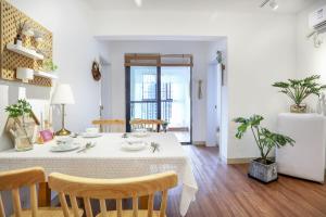 a dining room with a white table and chairs at Hefei Shushan·Daxidi· Locals Apartment 00162940 in Hefei
