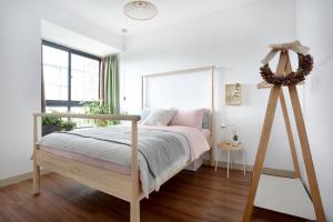 a white bedroom with a bed and a large window at Hefei Shushan·Daxidi· Locals Apartment 00162940 in Hefei