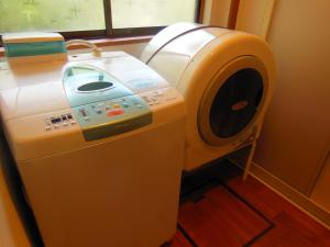 een wasmachine en droger in een kamer met een raam bij Japanese Style Inn Dohzen Miwa in Niimi