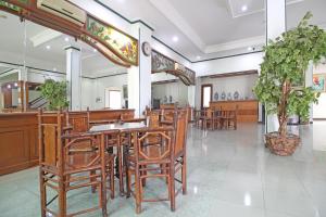 RedDoorz near XT Square Yogyakarta في يوغياكارتا: مطعم فيه كراسي وطاولات خشبية في الغرفة
