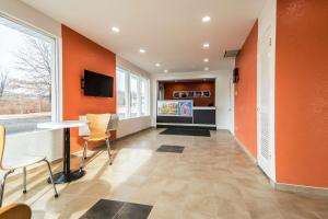 un bureau avec des murs orange, une table et des chaises dans l'établissement Motel 6-Schenectady, NY, à Schenectady