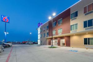 ein Hotel mit einem Parkplatz davor in der Unterkunft Motel 6 Fort Worth, TX - North - Saginaw in Fort Worth
