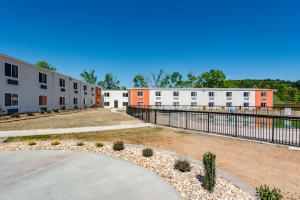 a row of apartment buildings with a fence at Motel 6-White, GA - Cartersville in White