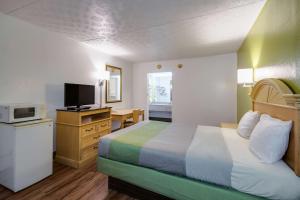 Habitación de hotel con cama y TV en Motel 6-Parkersburg, WV, en Parkersburg