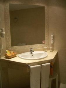 a bathroom with a sink and a mirror and towels at Costa do Sol B&B in Porto +21 photos
