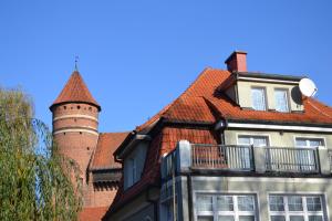 a house with a turret and a building with a balcony at Centrum25 in Olsztyn