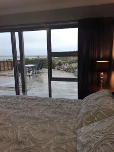 a bedroom with a bed and a view of a patio at Two Tuis Accomodation in Kaiteriteri