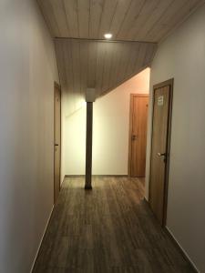 un corridoio vuoto con due porte e pavimenti in legno di Villa Midesta a Šiauliai
