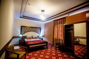 فندق أركانشي في خيوة: غرفة نوم بسرير وطاولة وكرسي