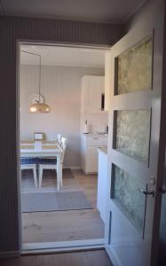 a kitchen with a table and a dining room at Putiikkihotelli Kemi 1932 in Kemi