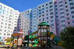 a playground in front of a large building at Apartment Erofey Arena at Sysoeva 8 in Khabarovsk
