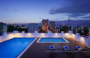 a swimming pool on top of a building with a city skyline at Citadines Regency Saigon in Ho Chi Minh City