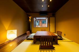 a dining room with a wooden table and chairs at Higashiyama Sho in Kanazawa