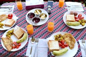 un tavolo con piatti per la colazione e succo d'arancia di Green Eco Resort a Kirtipur