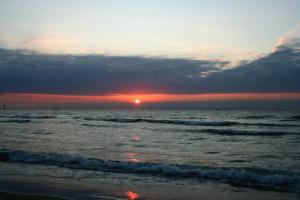 einen Sonnenuntergang am Strand mit Sonnenuntergang in der Unterkunft Spacious studio in Knokke-Heist