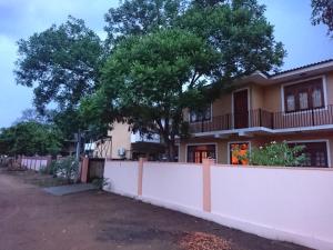 カタラガマにあるShiva Rest Katharagamaの白柵と木のある家