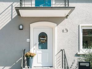 une porte blanche avec une couronne sur un bâtiment dans l'établissement 12 Kirschen, à Durbach