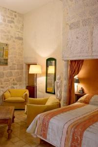 una habitación de hotel con 2 camas y una silla en Château de Fourcès, en Fourcès