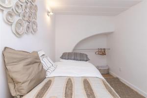 een slaapkamer met een bed, een kussen en een muur bij Travessa fiéis de deus in Lissabon